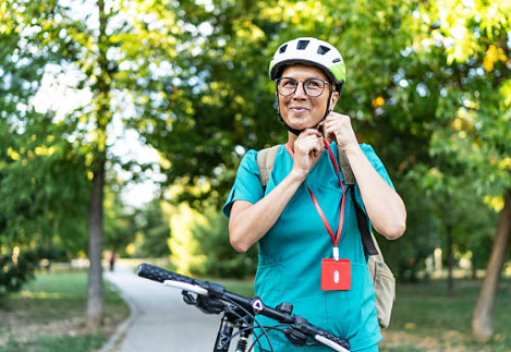 Happy girl putting on a bike helmet