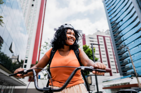 Happy girl putting on a bike helmet