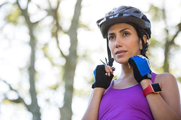 Woman sitting on his bike, wearing a bike helmet
