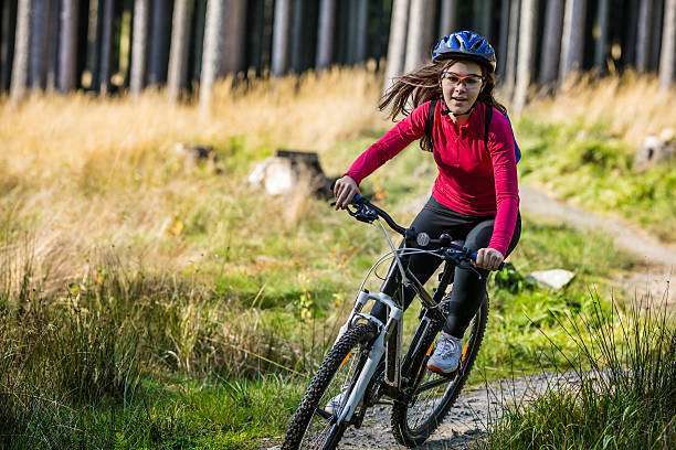 Woman sitting on his bike, wearing a bike helmet