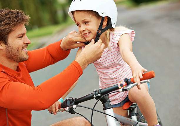 Woman sitting on his bike, wearing a bike helmet