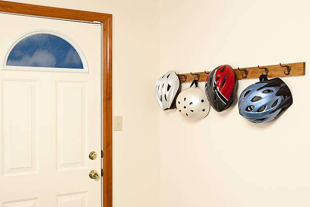 Bike helmet hanging on a coat rack by the door.