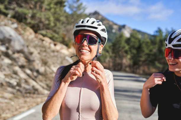 Smiling woman adjusting bike helmet