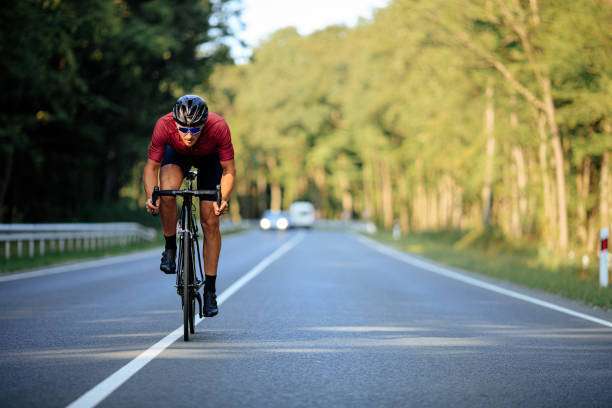 Man Riding Bicycle On Road, Wearing a bicycle helmet