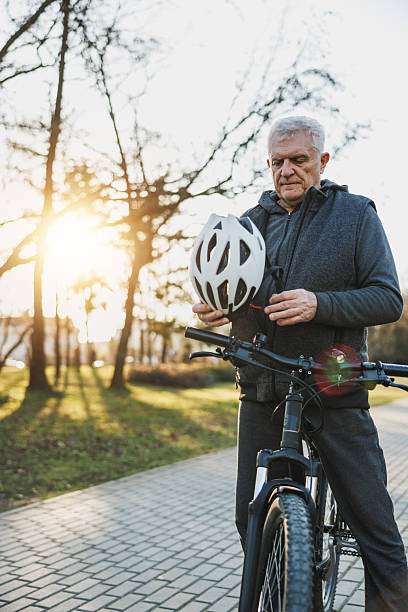 man is holding and inspecting a bike helmet.