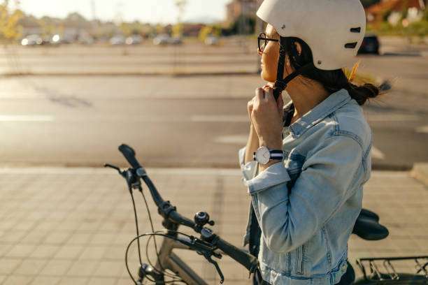 Young woman putting her bike helmet, preparing for the bike ride