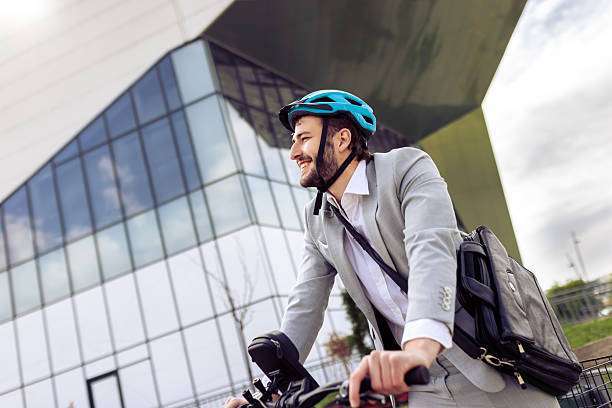 Young businessman riding, wearing a bike helmet
