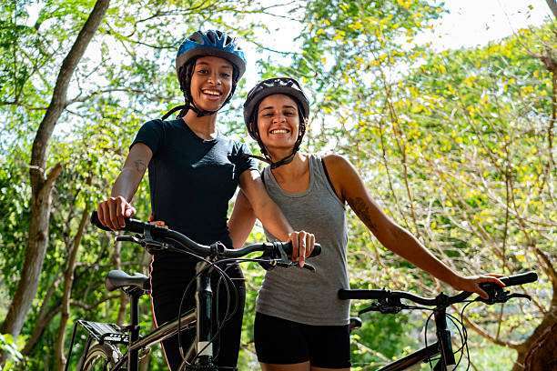 Portrait of young cyclists women on public park.bike helmet