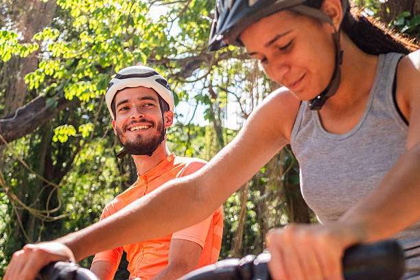 Beautiful and young African American woman riding, wearing a bike helmet