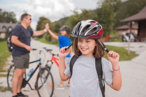 Happy young girl taking off bike helmet