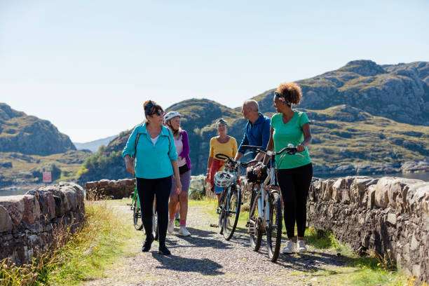 Group of people walking with bikes and wearing bike helmet