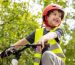 Happy boy in red bike helmet and safety vest rides bike.