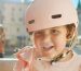Happy child wearing pink bike helmet outdoors.