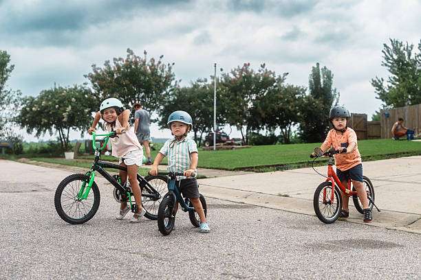 boy wearing a bike helmet rides a scooter in the driveway