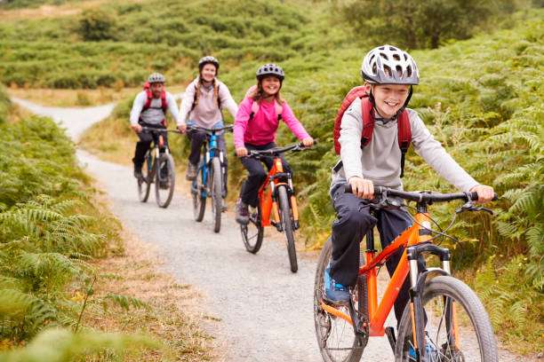 Family cycling on a path wearing bike helmets.