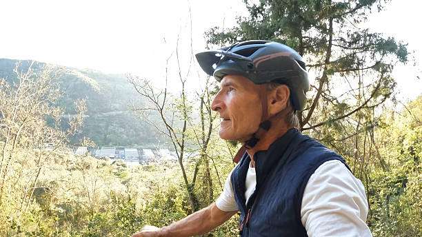 Man wearing bike helmet and cycling gear on trail.