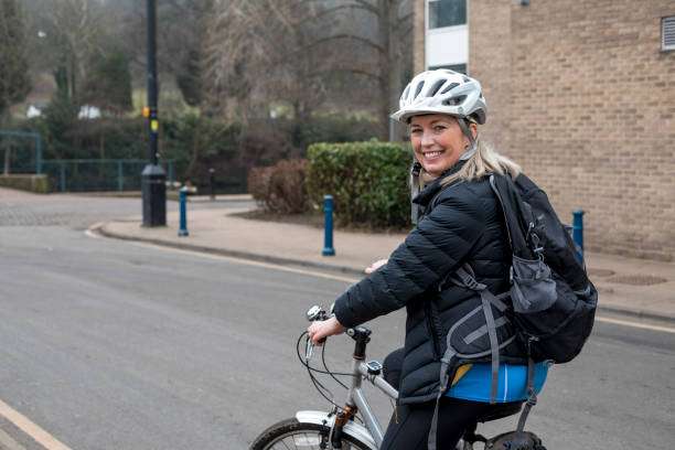 Biker girl putting on a protective bike helmet
