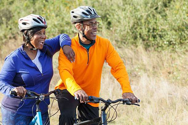 Couple with bike helmets enjoying a cycling outing outdoors.